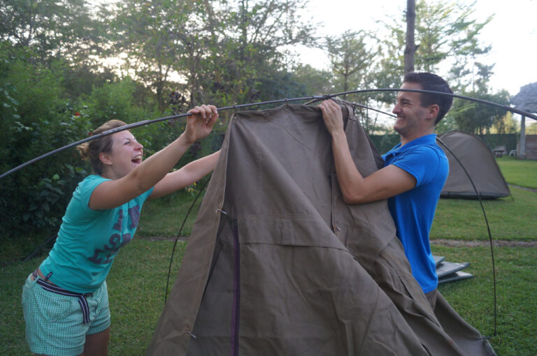 Travelers setting up tent at campsite