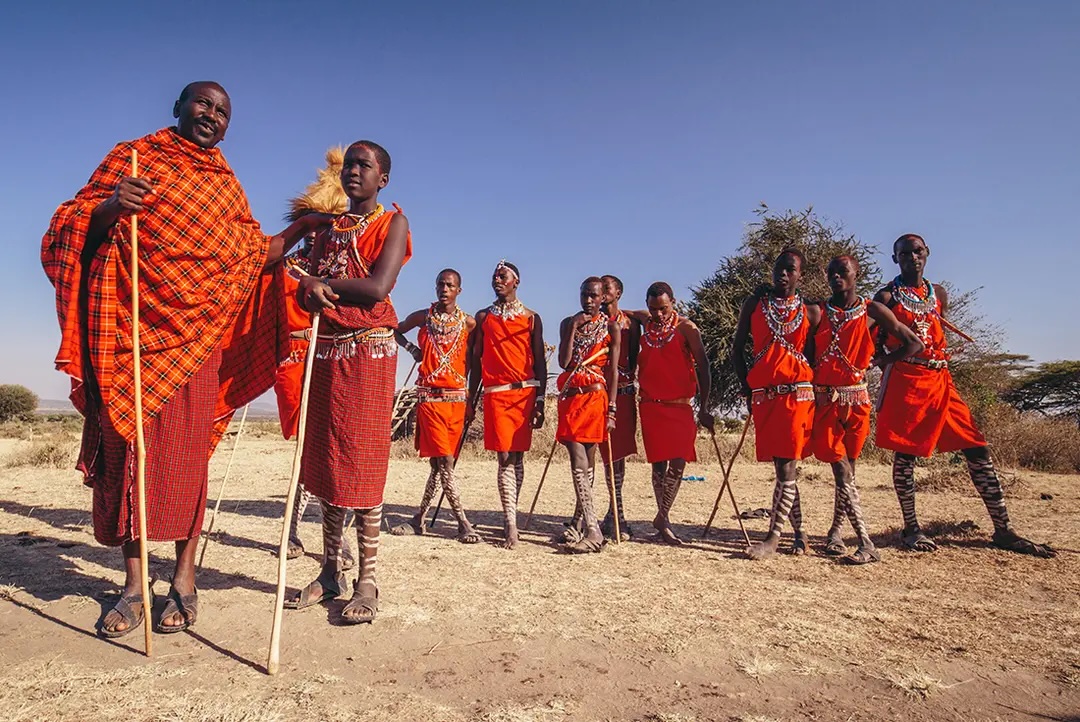 Group of masai people dressed in red traditional clothing.