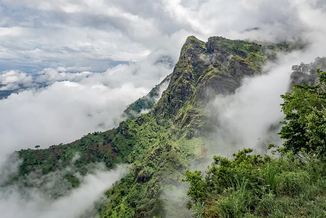 Lush green mountains amidst clouds