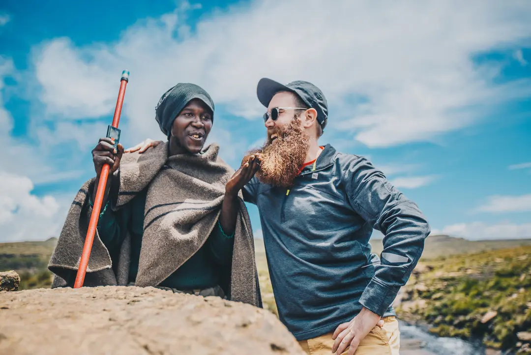 Male traveler laughs with local in Drakensberg.