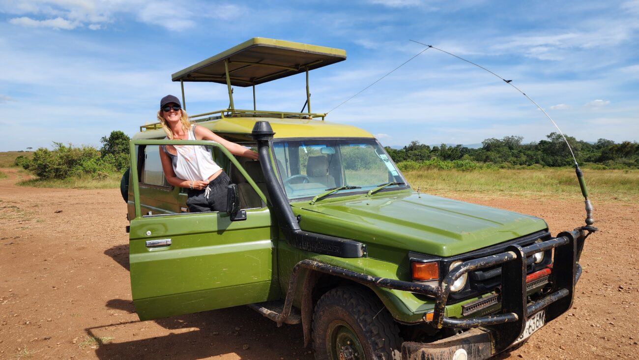 Happy female leans out of green pop-up roof vehicle